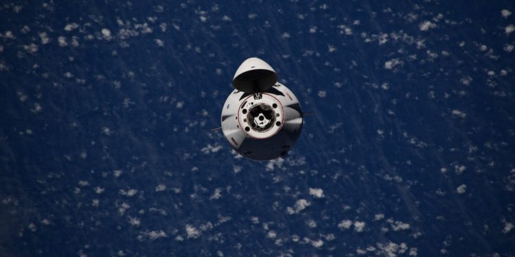 Dragon supply freighter docks at space station with 2.4 tons of cargo