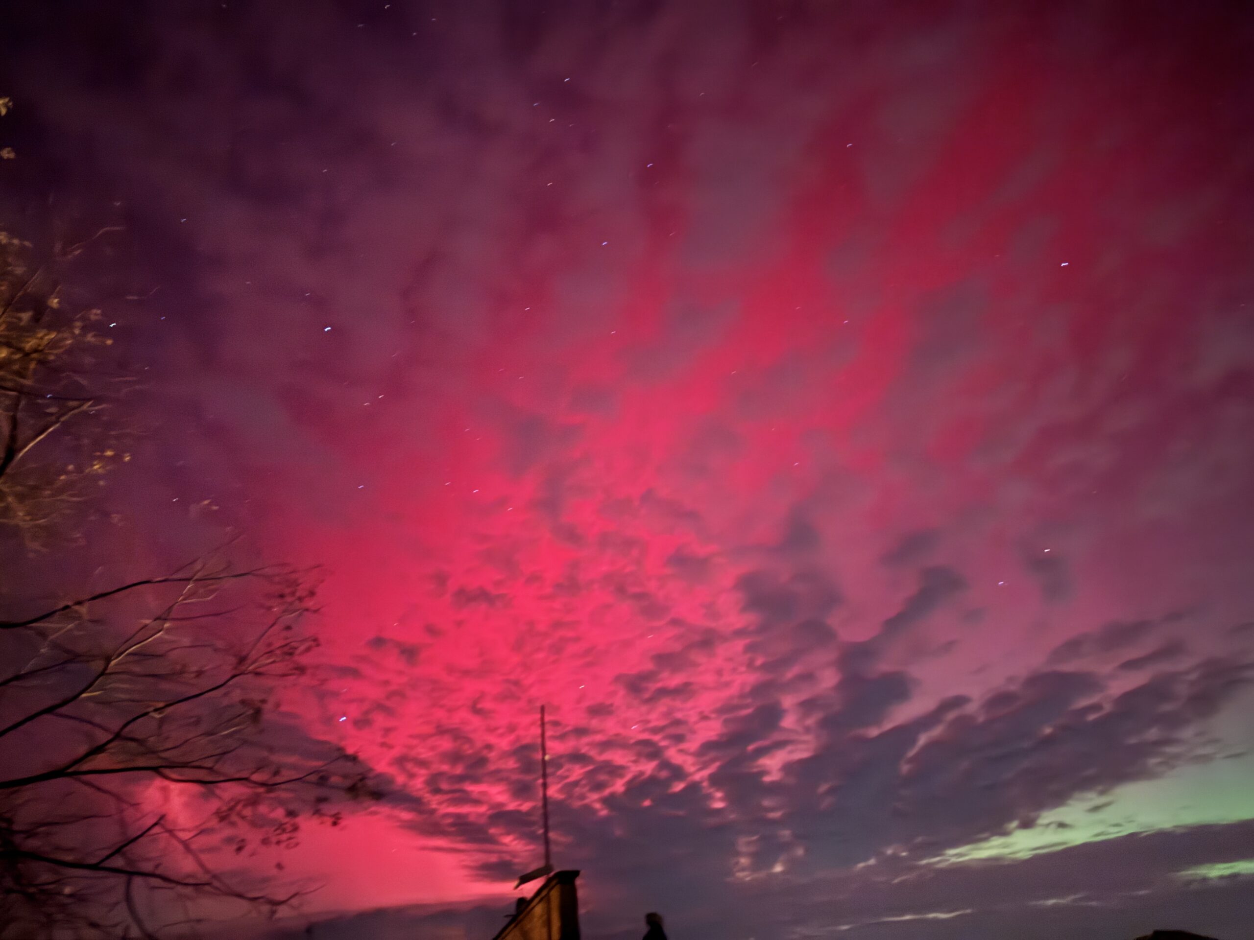 northern lights appear as curtains of red and green light in the sky.