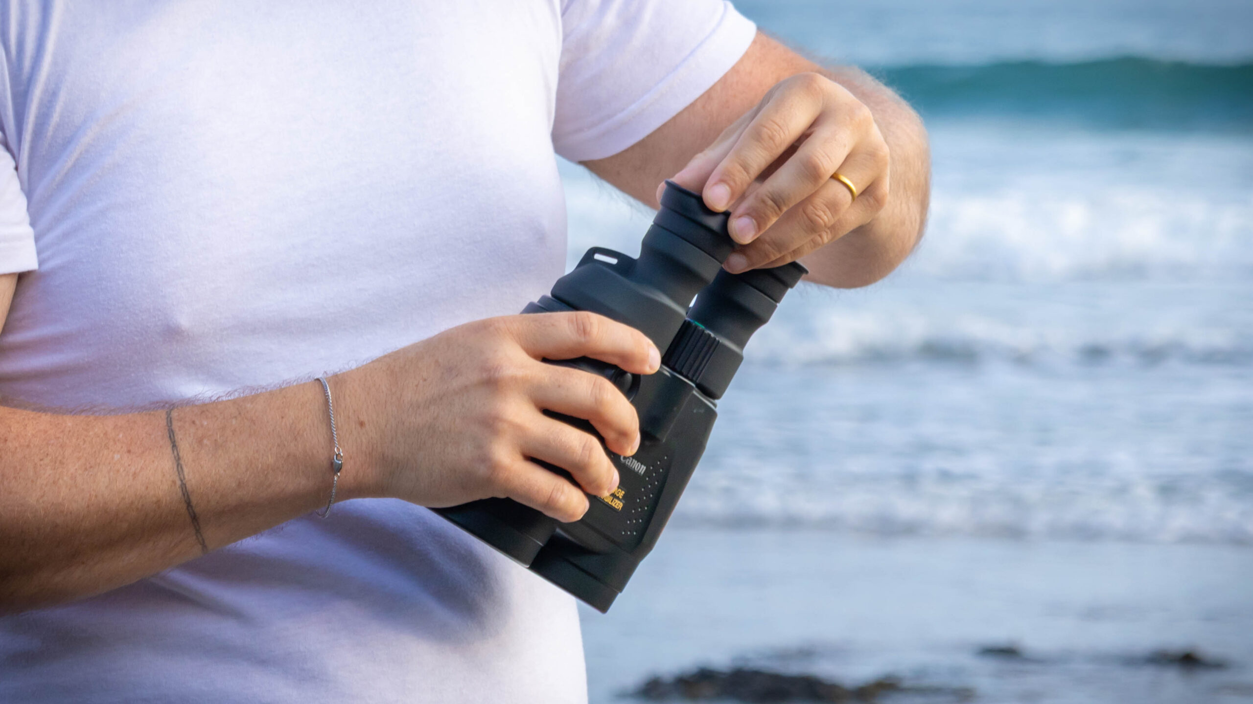 A close up of the eyecups being adjusted to the flap up position on the Canon 18x50 IS binoculars.