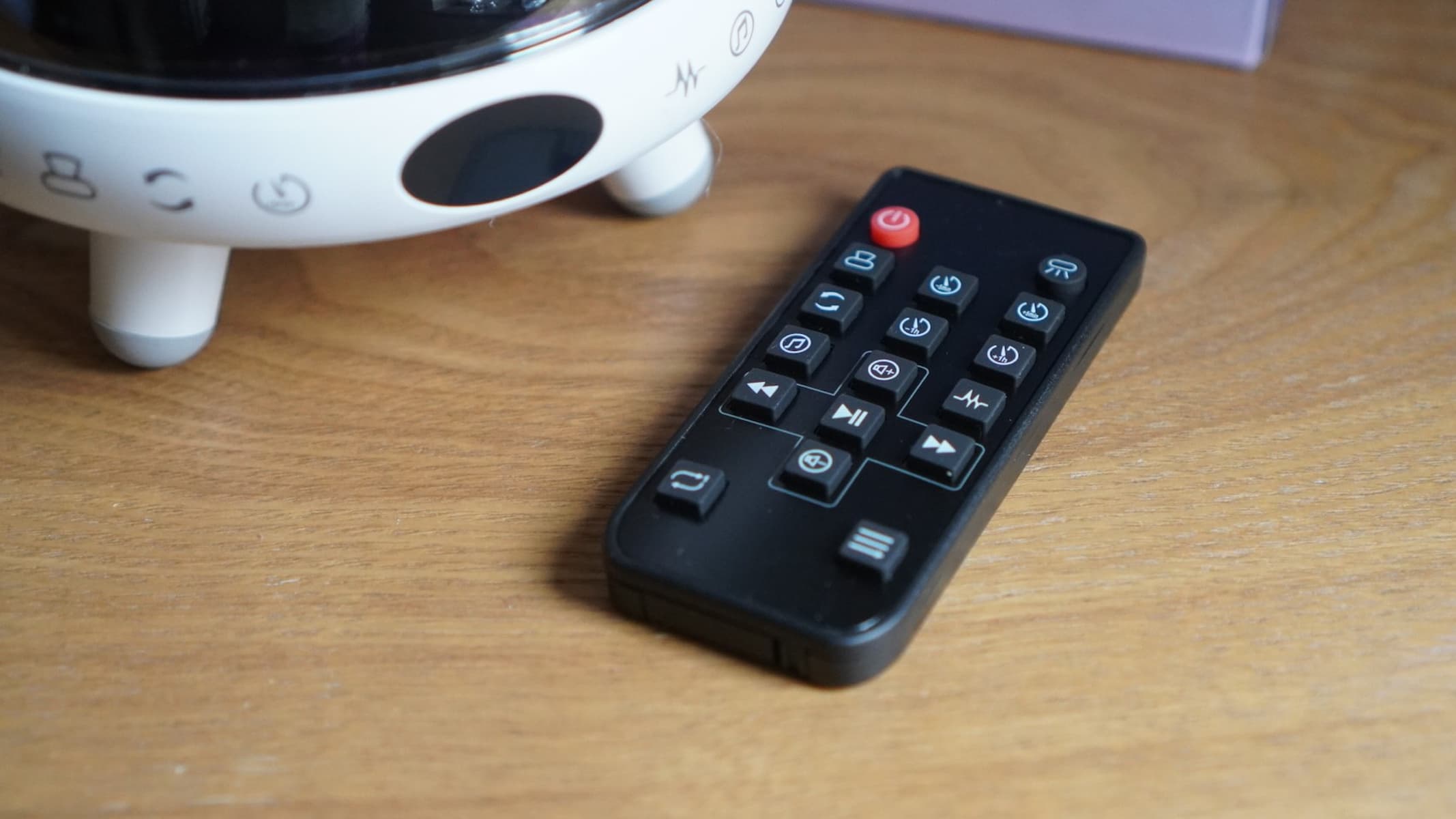 The remote for a Yachance Night Light star projector, on a table.