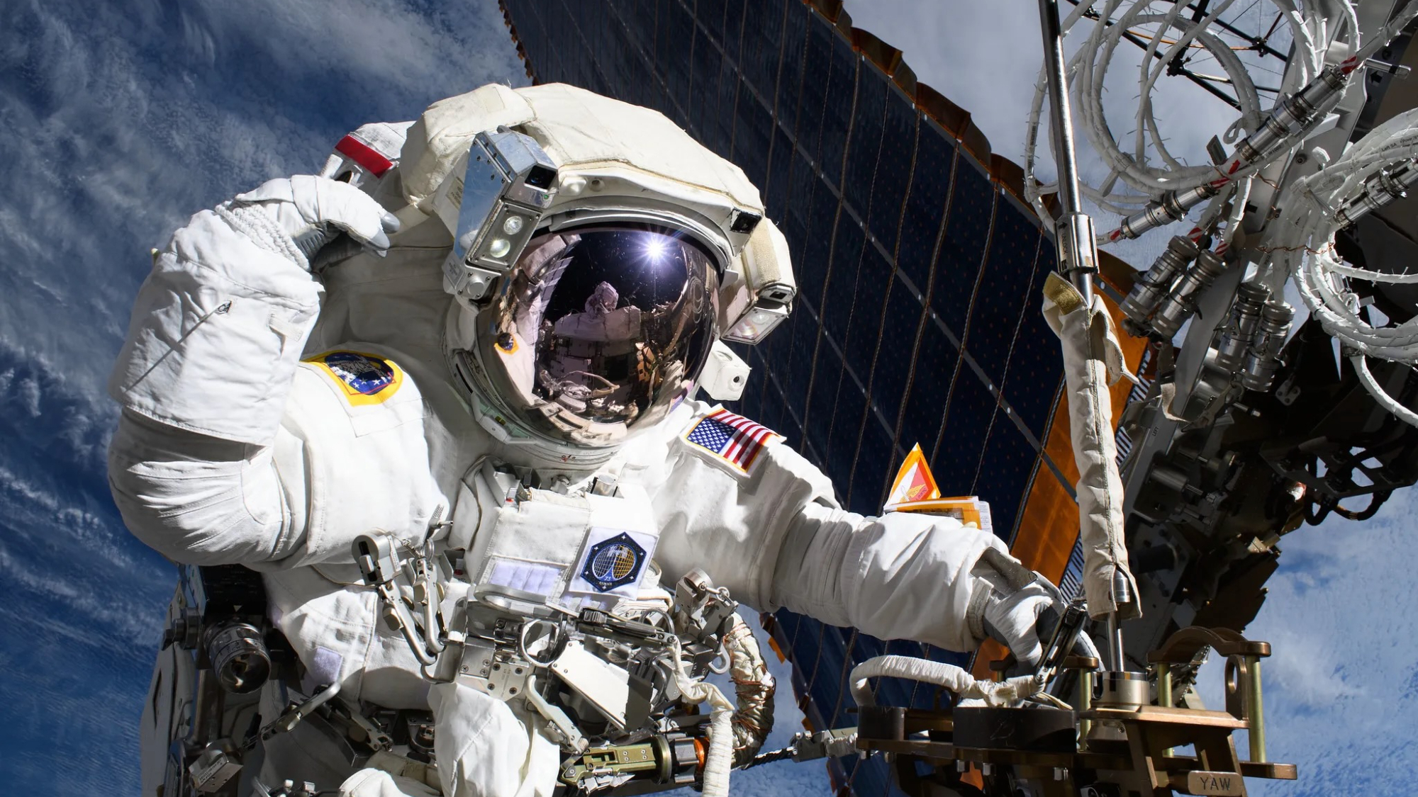 closeup photo of a spacewalking astronaut working outside the international space station with earth in the background