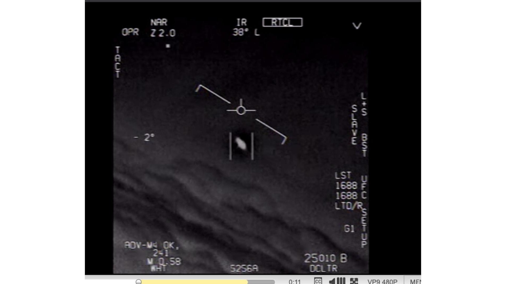 black and white photo taken by a fighter jet's camera, showing a whitish disk glowing in a cloudy sky