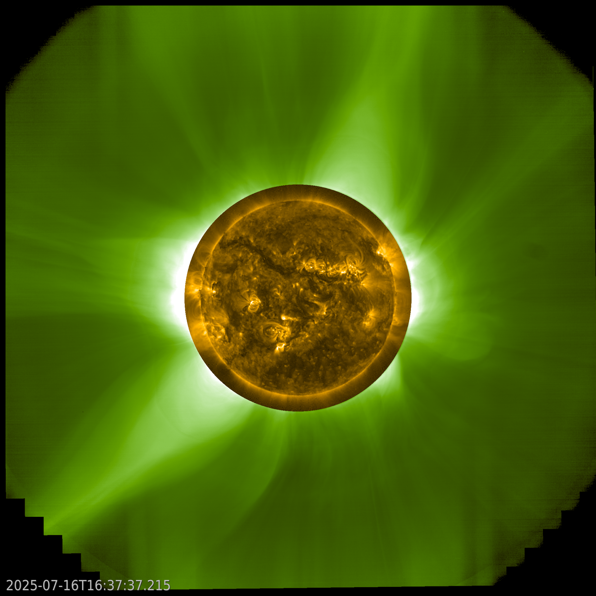 A square image with the Sun in the centre. The Sun looks yellow, with bright and dark regions. Surrounding this central image is a different image in green, showing green glowing arcs and rays extending out from the Sun. Two large rays stand out in the top centre-right and bottom left