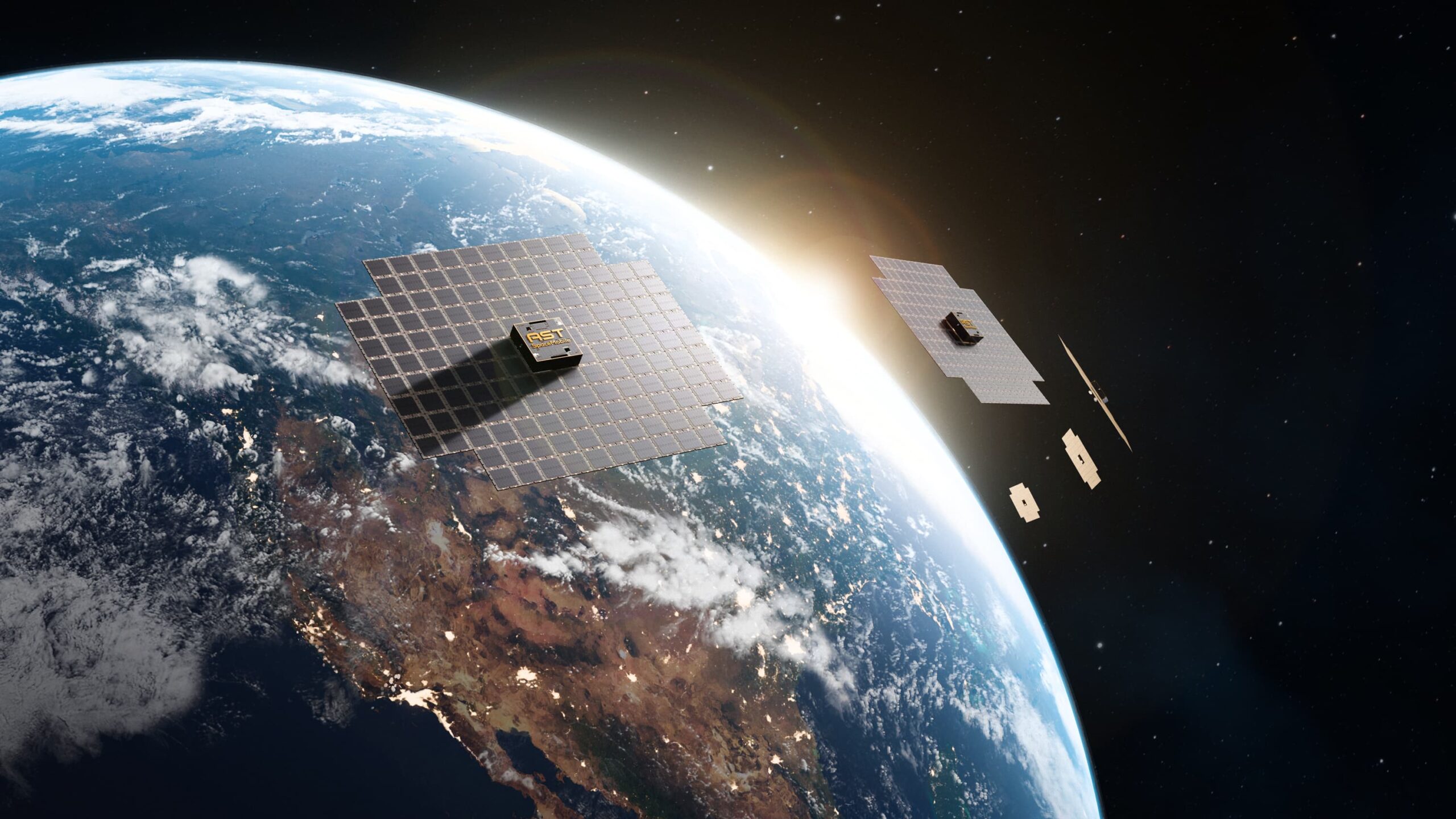 a satellite constellation with large solar array panels are seen in orbit above a blue, white and brown planet as the sun rises on the horizon
