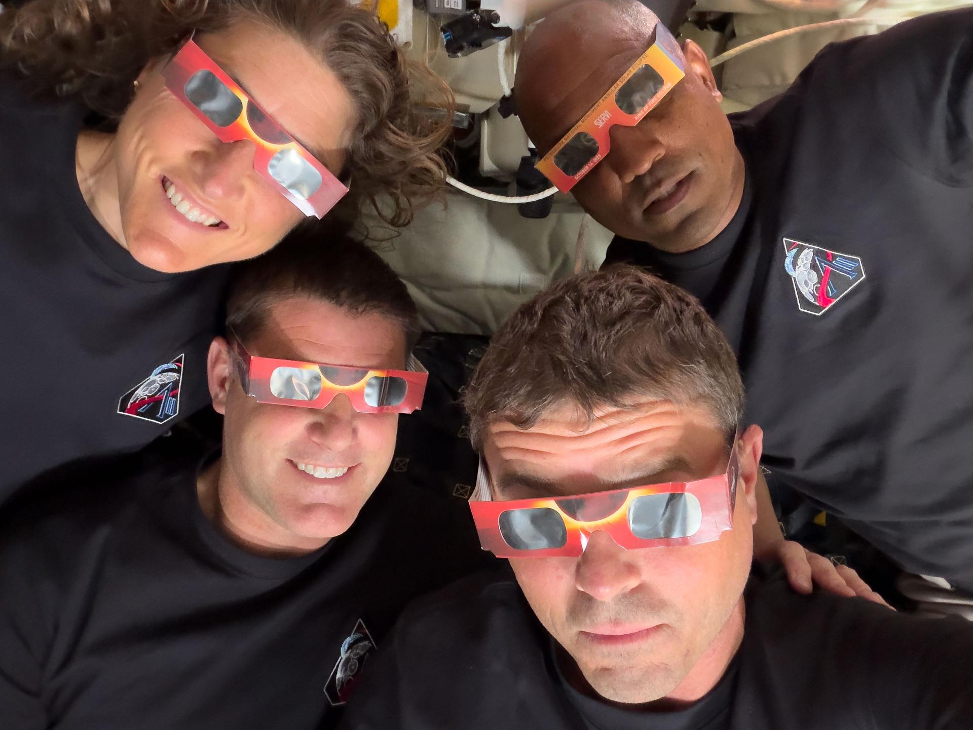 NASA's Artemis 2 crew are pictured wearing eclipse glasses and smiling