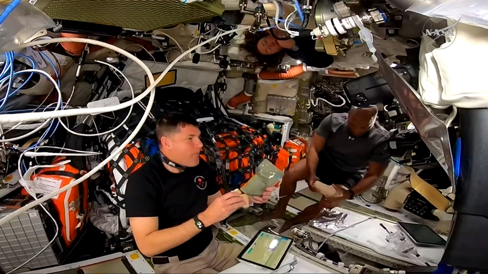 NASA astronaut Victor Glover (right) prepares to take a towel bath inside the Orion spacecraft on the way to the moon on April 3, 2026.