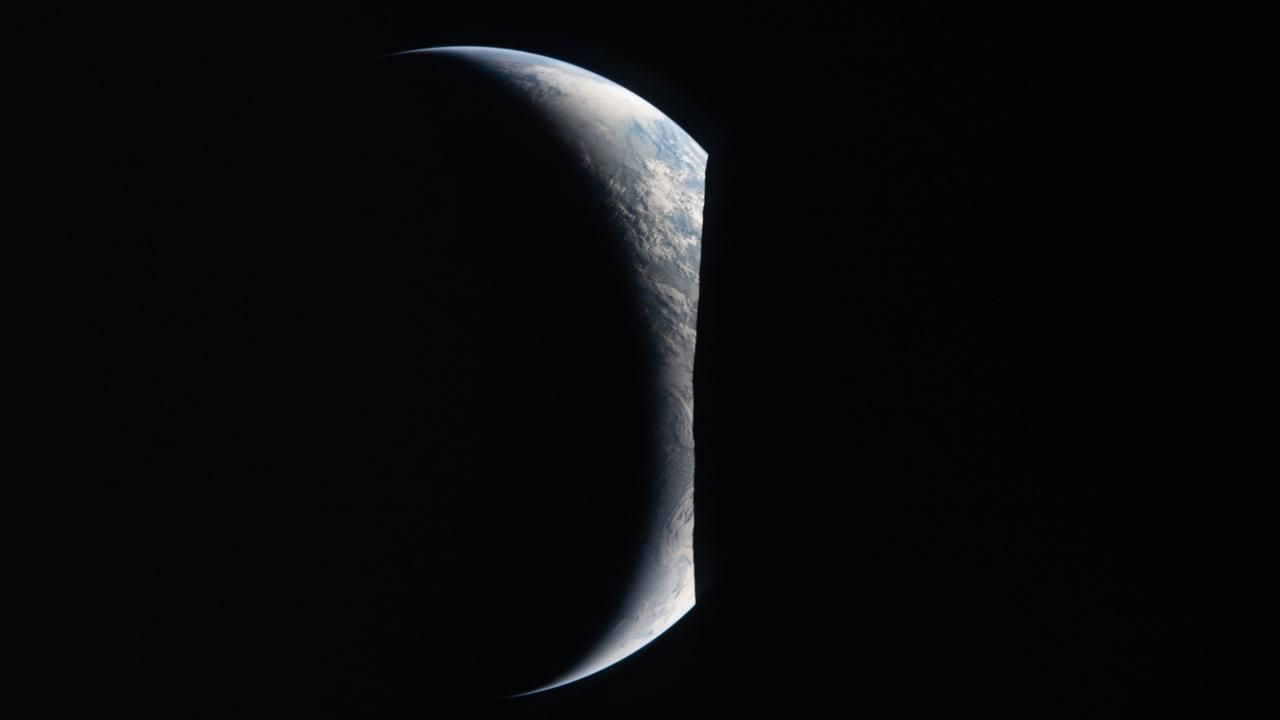 A crescent Earth is pictured emerging from behind the night side of the moon by the Artemis 2 crew.