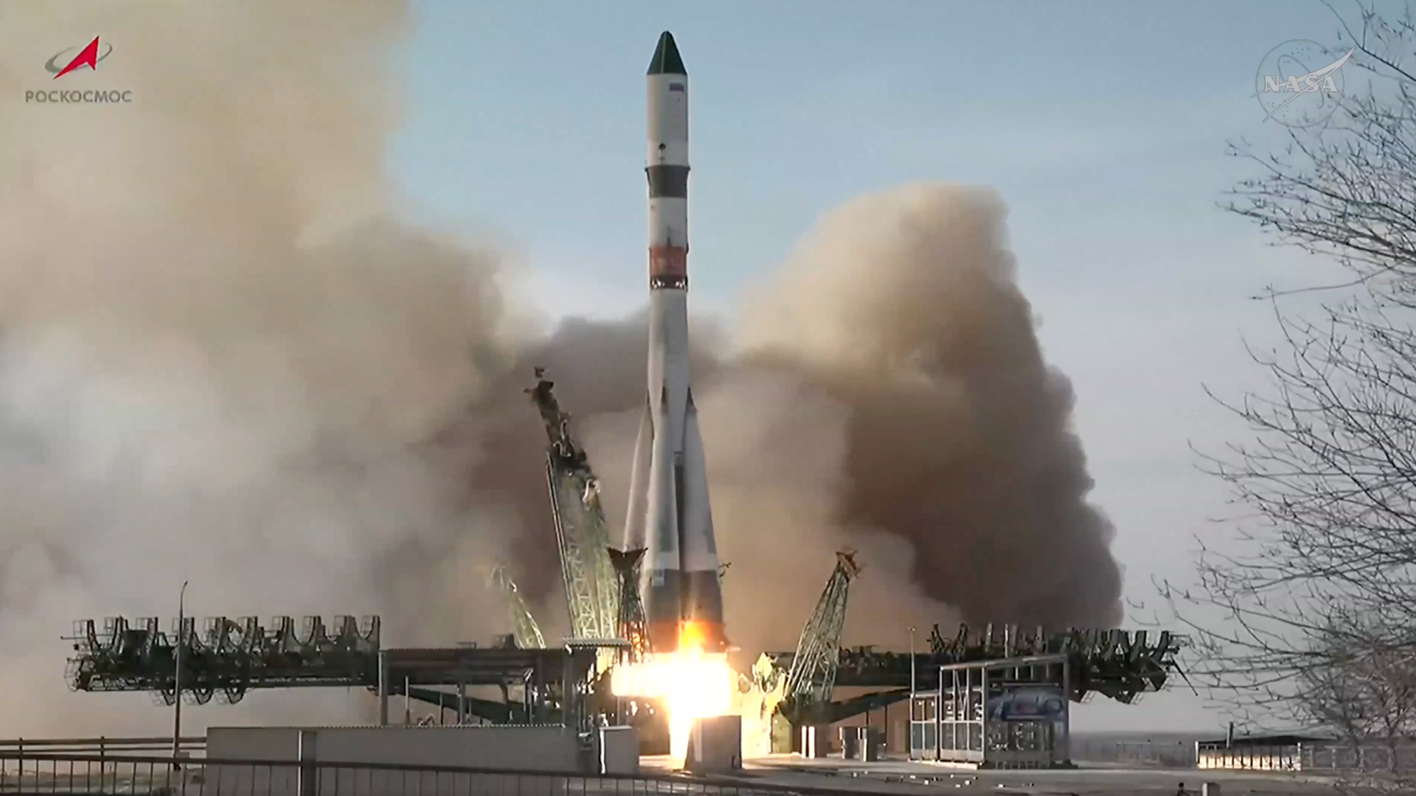 a large white rocket launches into a cloudy sky