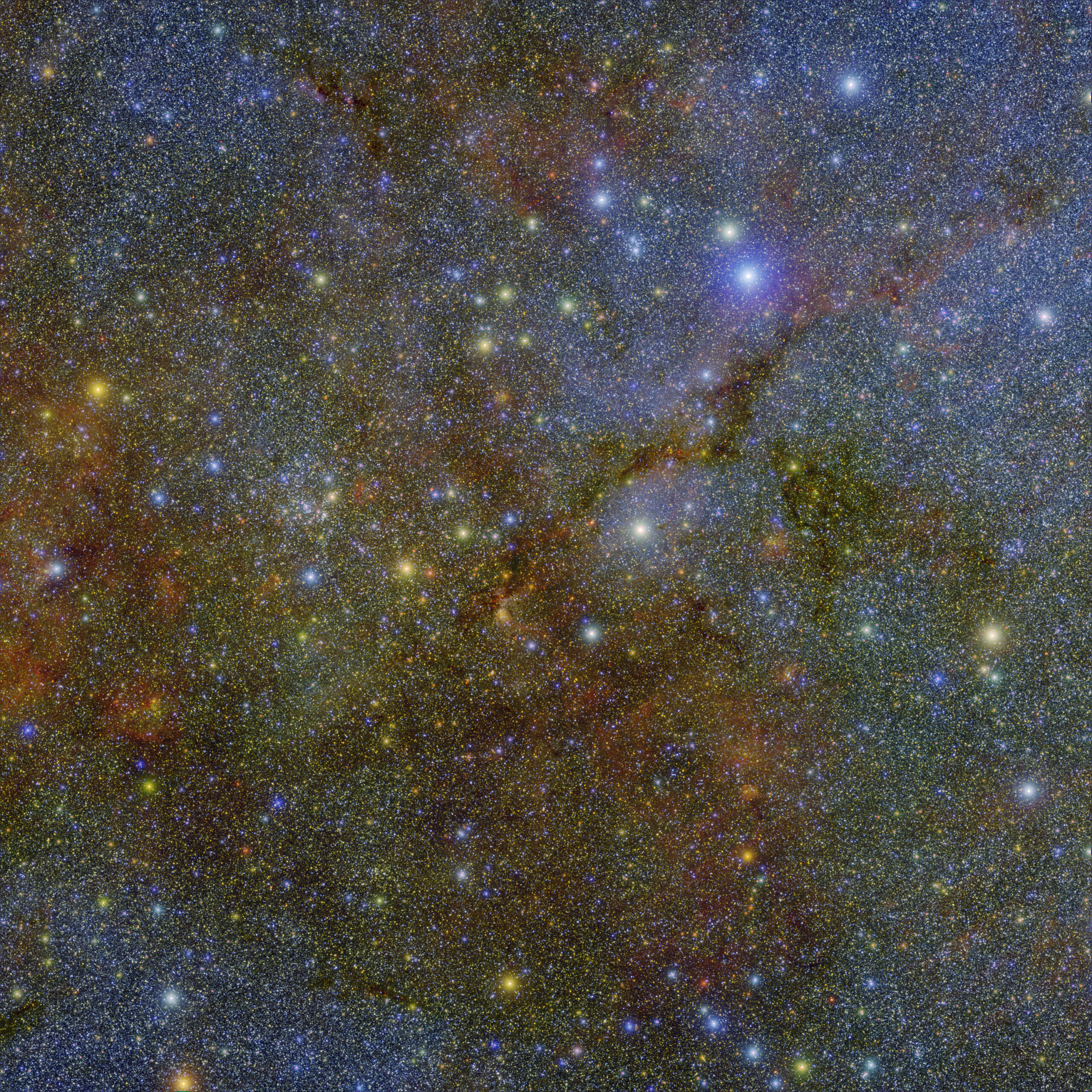 An extremely starry blueish patch of sky with glowing dots and some tendrils of brown and greenish yellow in the back.