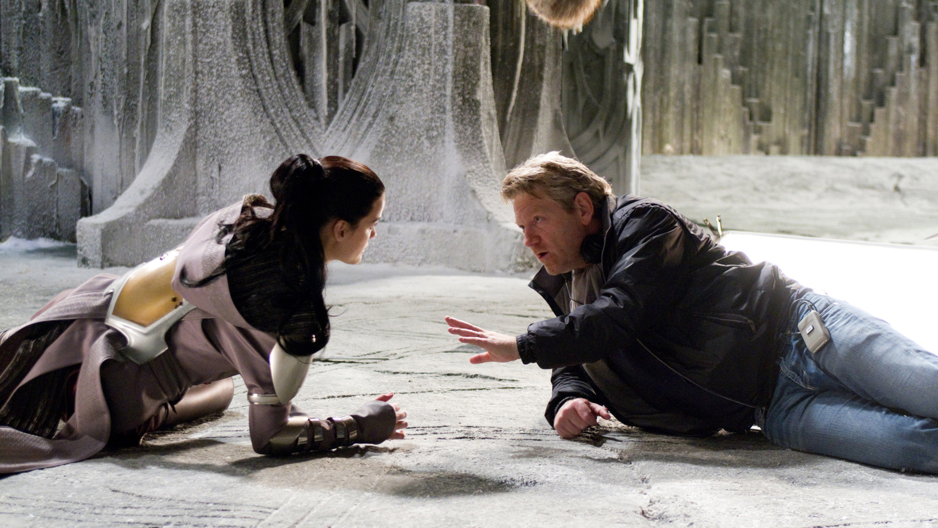 Screenshot from the 2011 sci-fi super hero movie "Thor" showing director Kenneth Branagh giving direction to Jaimie Alexander, who plays Sif.